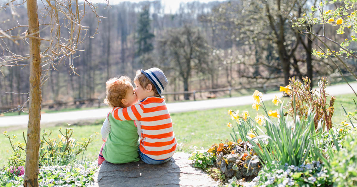 two adorable toddlers sitting in the garden among the flowers :: photo copyright Karin Bergmann